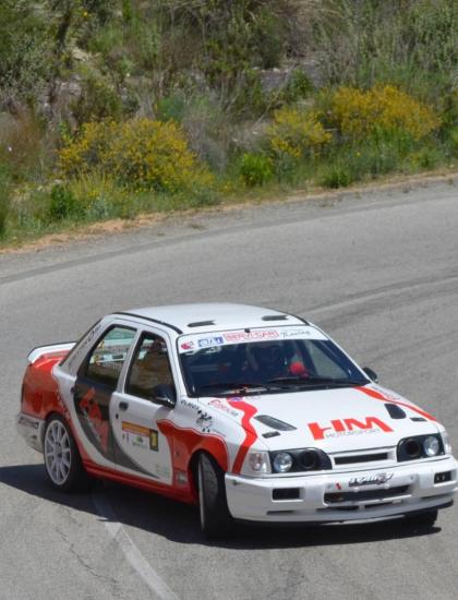 Auto da rally affronta una curva su strada di montagna.