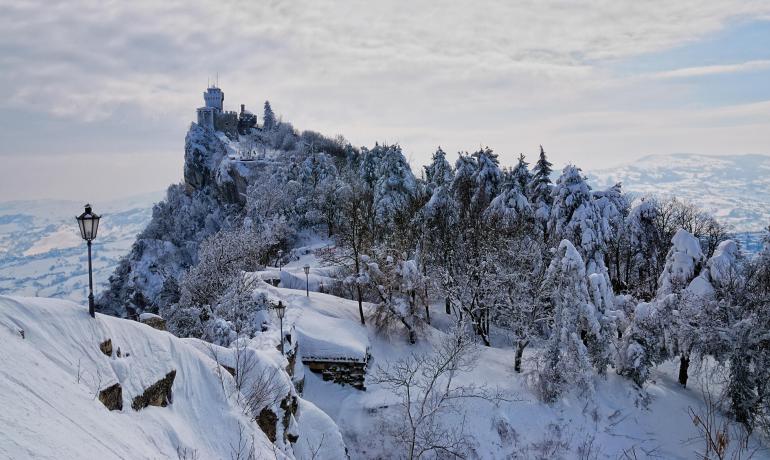 Castello innevato su una collina con vista panoramica.