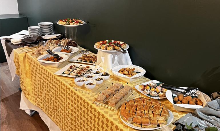 Buffet with assorted dishes on a table with yellow tablecloth.