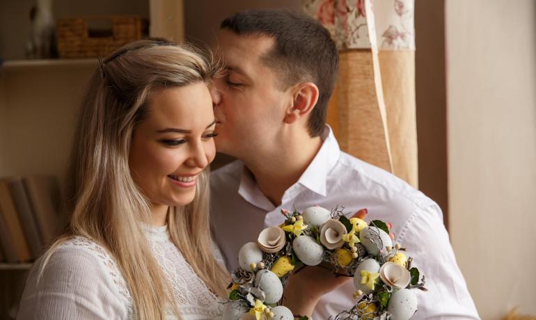 Couple heureux avec couronne florale chez eux.