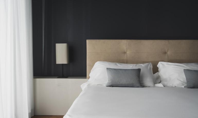 Camera da letto moderna con letto matrimoniale e lampada da comodino.