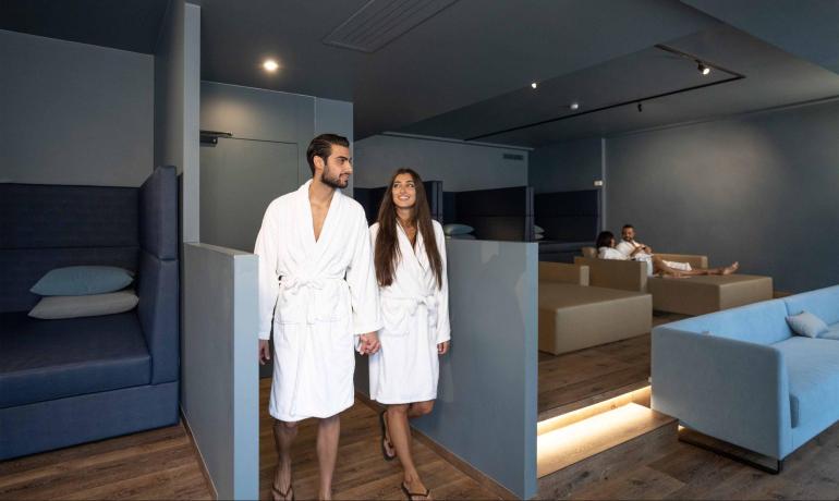 Couple in bathrobes walking in a modern spa.