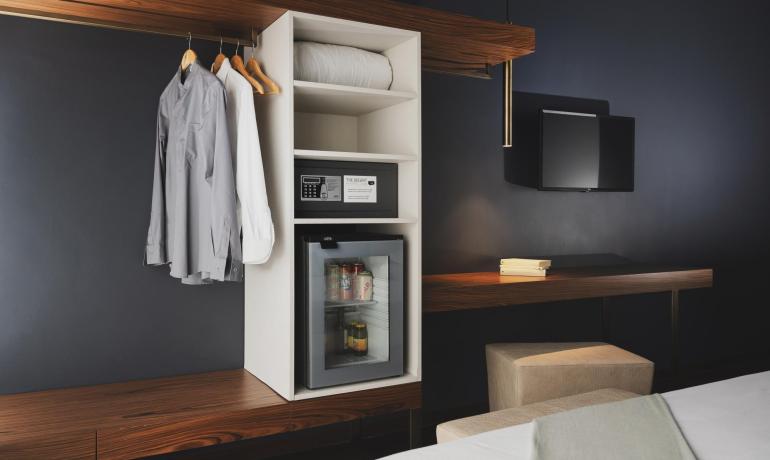 Camera d'albergo moderna con cassaforte, minibar e scrivania.